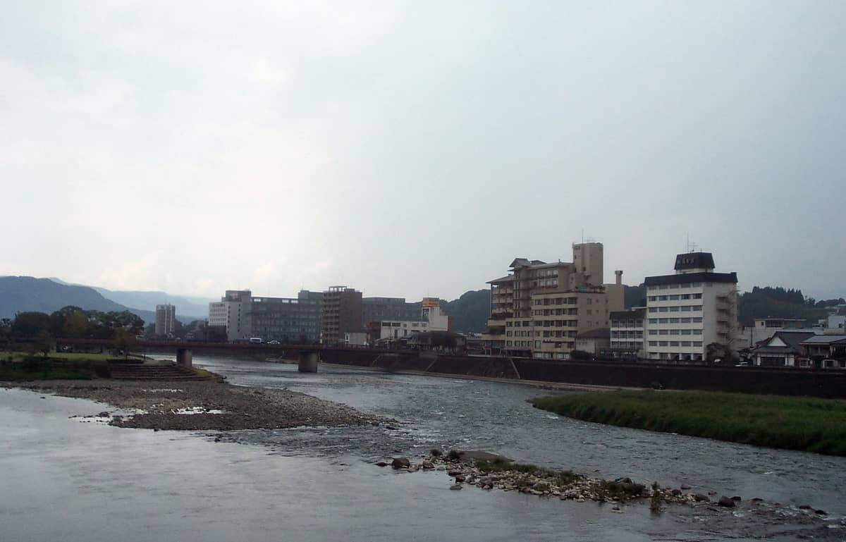 人吉市區球磨川沿岸景色,河岸建築與遠山
