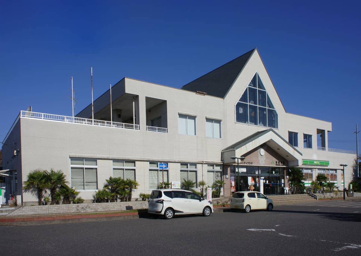 JR須賀川站站舍外觀,白色建築與站前廣場車輛