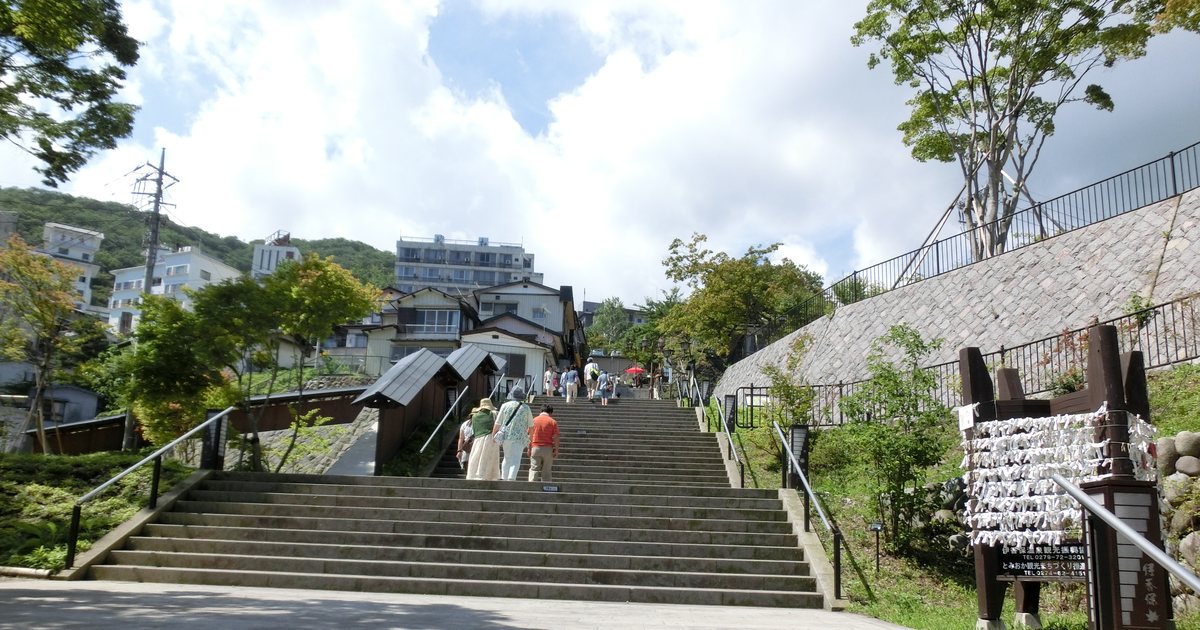 伊香保石段街:寬闊的石階沿著山坡往上,兩側是綠樹與依山而建的溫泉旅館
