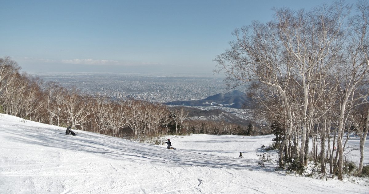 サッポロテイネ 的壓雪滑道從白樺林之間往下延伸,坡底遠方是攤開到地平線的札幌市區與石狩平野