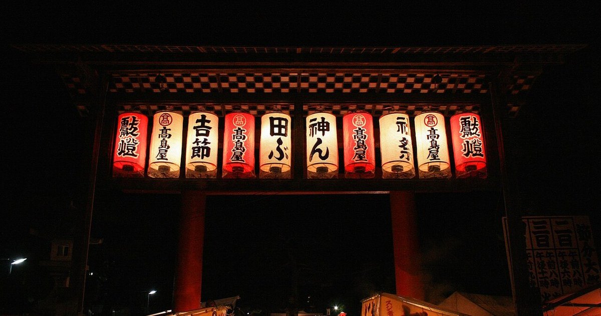 節分當晚的京都吉田神社鳥居,掛滿寫著「節分」「厄除」的提燈,底下是排到看不見盡頭的露店與人潮
