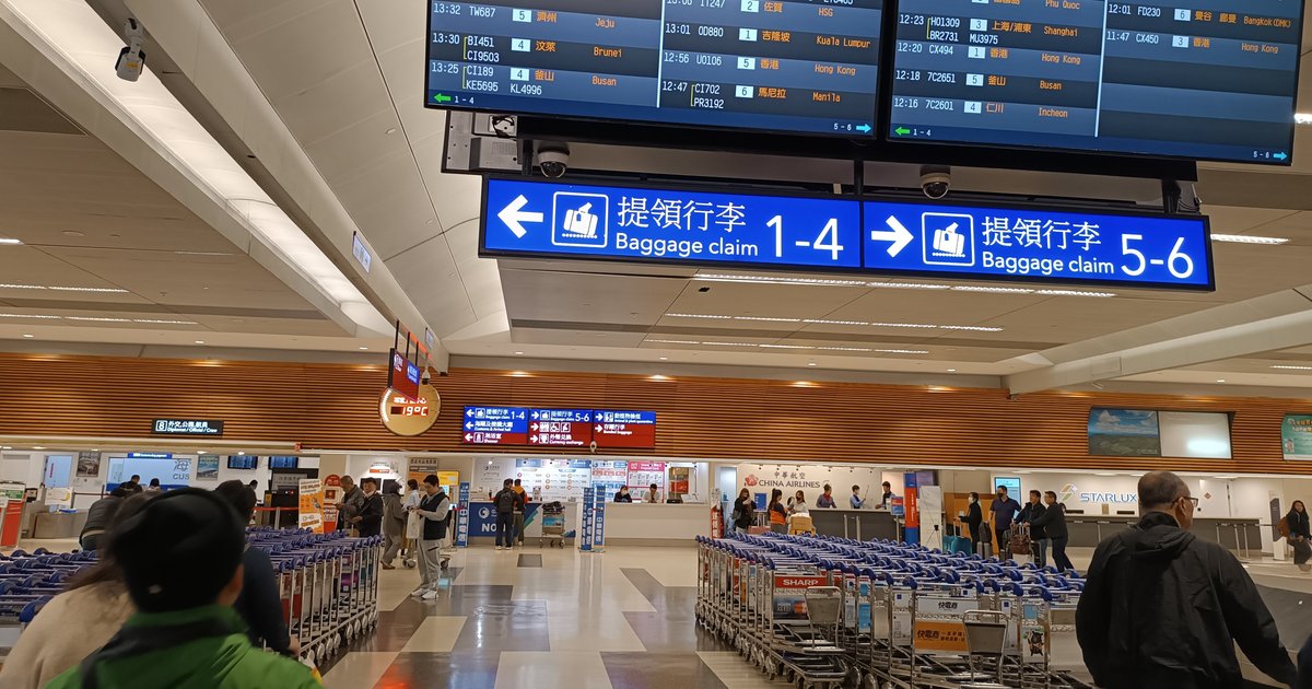 桃園國際機場入境行李提領大廳,提領行李指示牌、日本航班的行李轉盤看板與成排行李推車