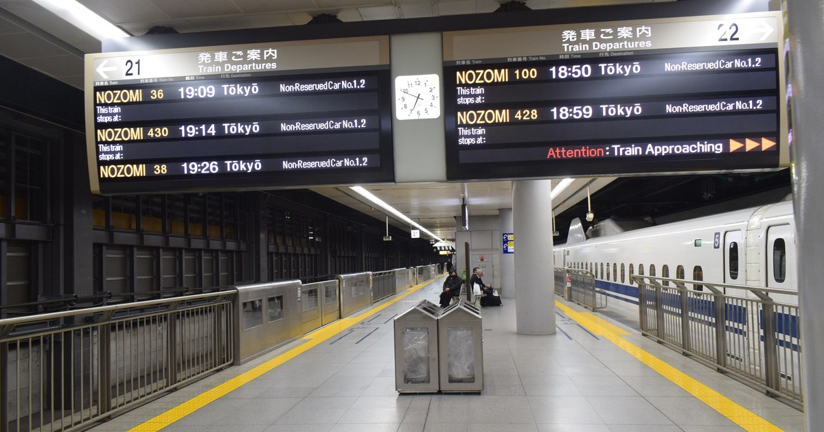 品川站新幹線月台,停靠中的列車車門旁標著車廂編號,頭上的發車資訊看板列出のぞみ班次與自由席車廂位置