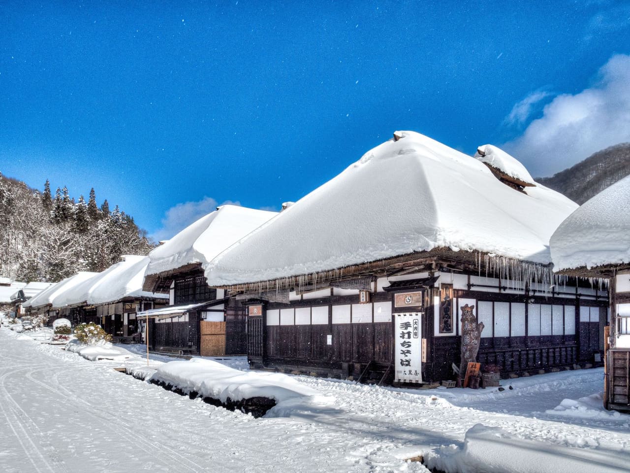 大內宿冬季雪景,茅葺屋頂積著厚雪的老街