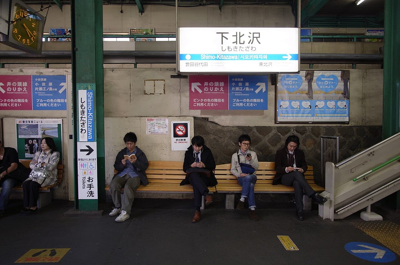 日本電車月台:旅客在車站等車,手機導航與轉乘 App 是日本都市移動最常用的工具