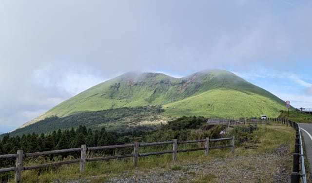 阿蘇草千里:火山外輪山的草原與遠方煙霧