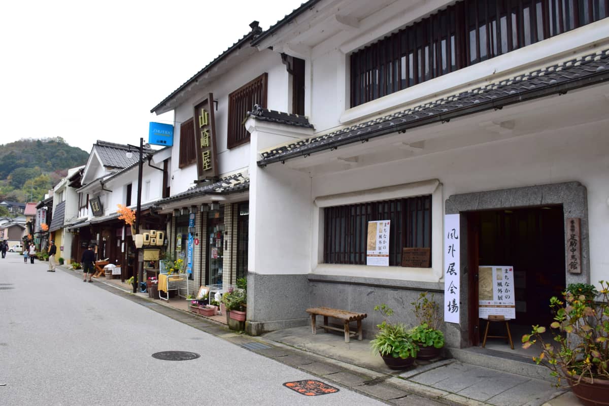 足助老街街景:白牆土藏與木造町屋沿舊飯田街道並排,右側是足助中馬館