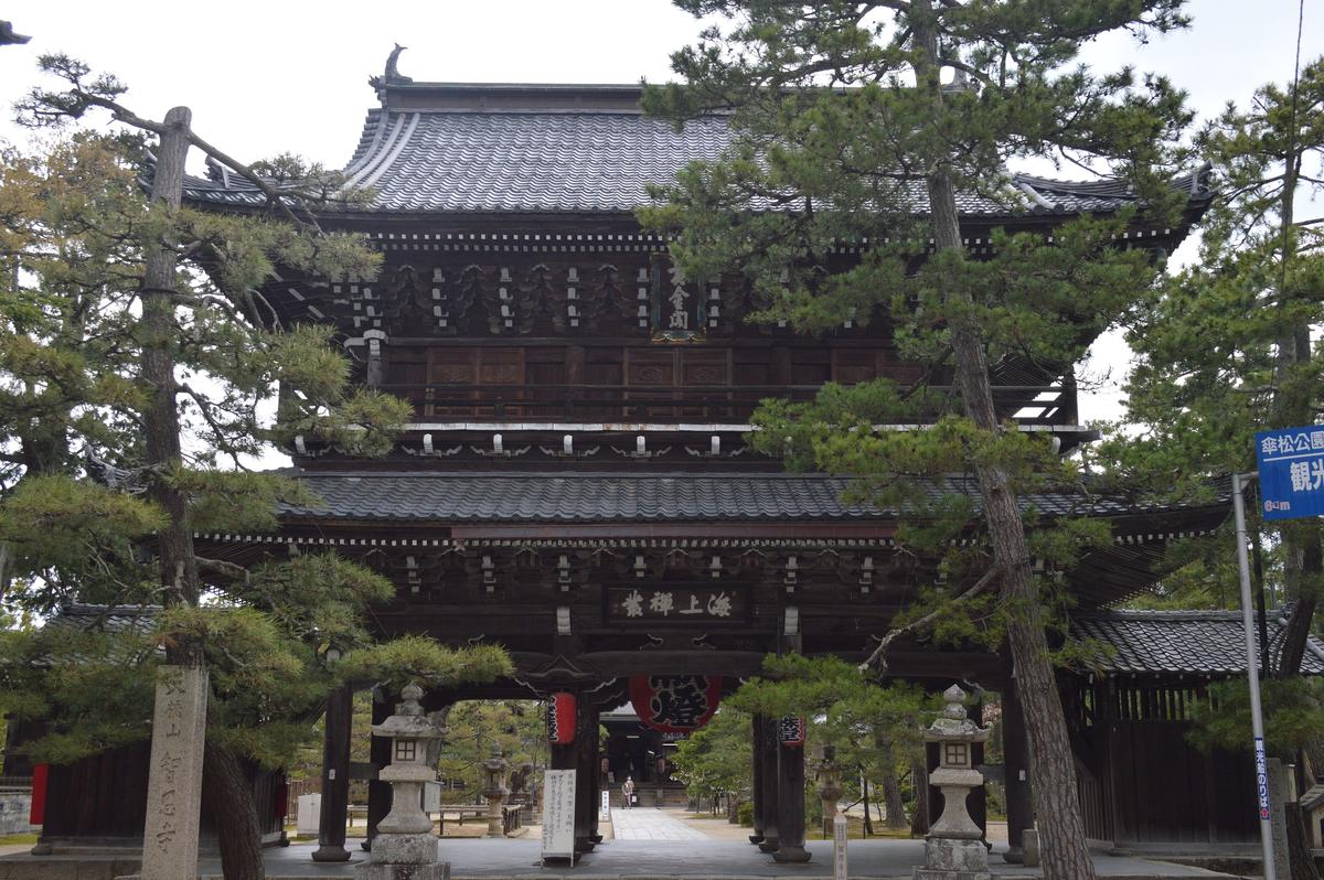 智恩寺的二層山門，門額寫著海上禪叢，門前有石燈籠與松樹，右側立著往傘松公園與觀光船乘船處的指示牌