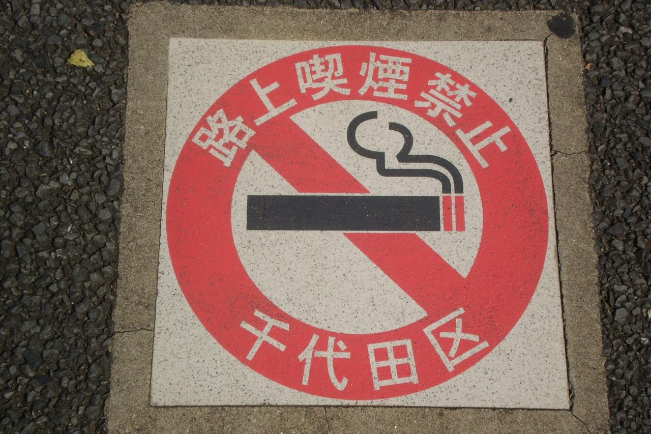 千代田區人行道上的路面標示板,紅圈內為禁菸圖示,外圈寫著路上喫煙禁止與千代田区