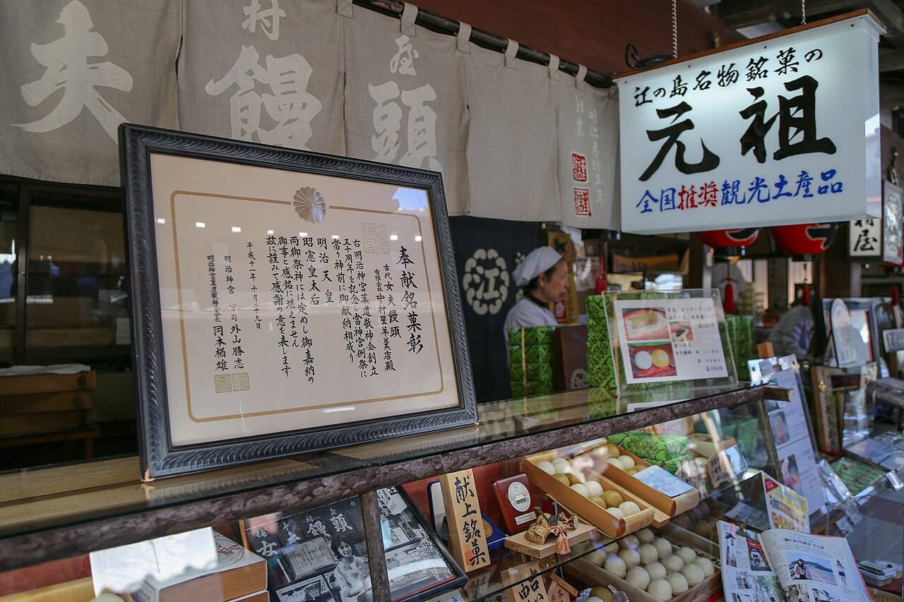 中村屋羊羹店的店頭,「江の島名物銘菓の元祖」看板、明治神宮奉獻銘菓彰狀與玻璃櫃內的和菓子