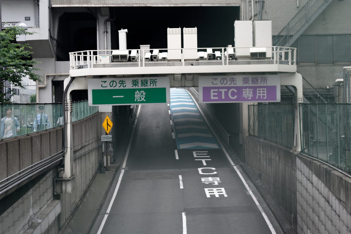 日本都市高速的車道分流看板:左側綠底白字寫「一般」、右側紫底白字寫「ETC 専用」,右側路面同時漆有 ETC専用 字樣