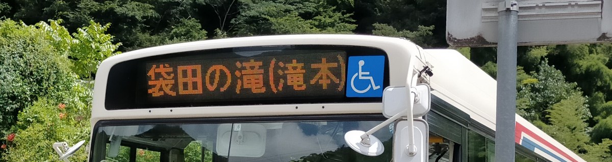 茨城交通路線巴士的車頭 LED 方向幕,橘字寫著「袋田の滝(滝本)」,右邊是藍底白色輪椅標誌,車身米白配紅藍線條