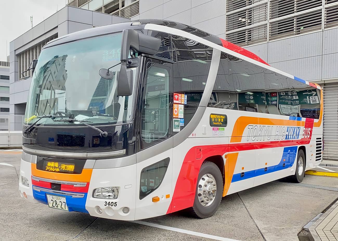 東急高速巴士的白底紅藍橘塗裝高速巴士，車頭方向幕寫著「御殿場アウトレット・河口湖駅」，車身側面標示 TOKYU HIGHWAY BUS