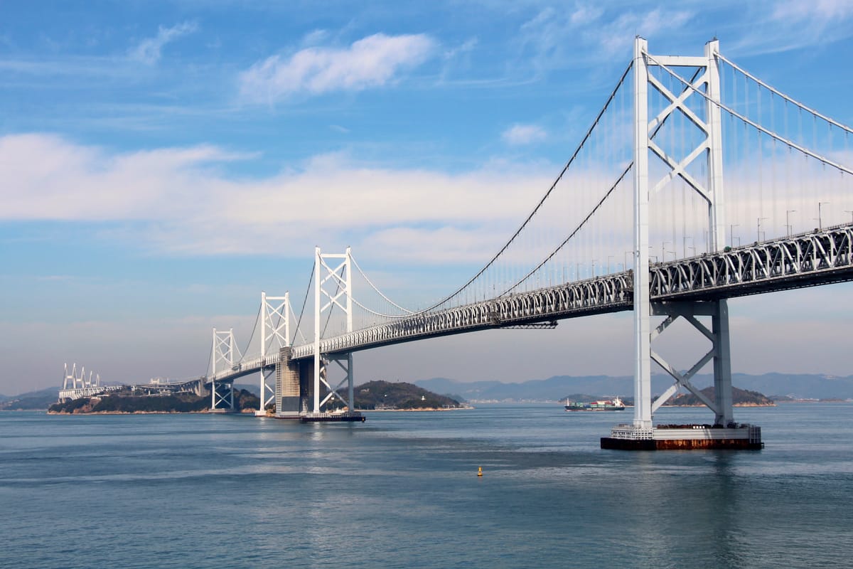 瀨戶大橋南備讚瀨戶大橋段的遠景,白色吊橋主塔連續跨越瀨戶內海,橋墩立於海中