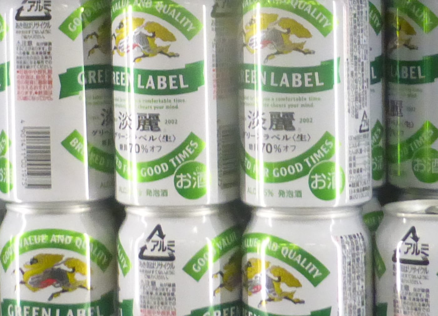 日本罐裝酒罐身下緣的品目標示特寫:麒麟淡麗綠標的白色鋁罐上,綠色緞帶下方印著「淡麗 グリーンラベル〈生〉 糖質70%オフ」,罐底邊緣一行小字寫著「ALC.5.5% 発泡酒」,右邊是綠色圓形的「お酒」標記