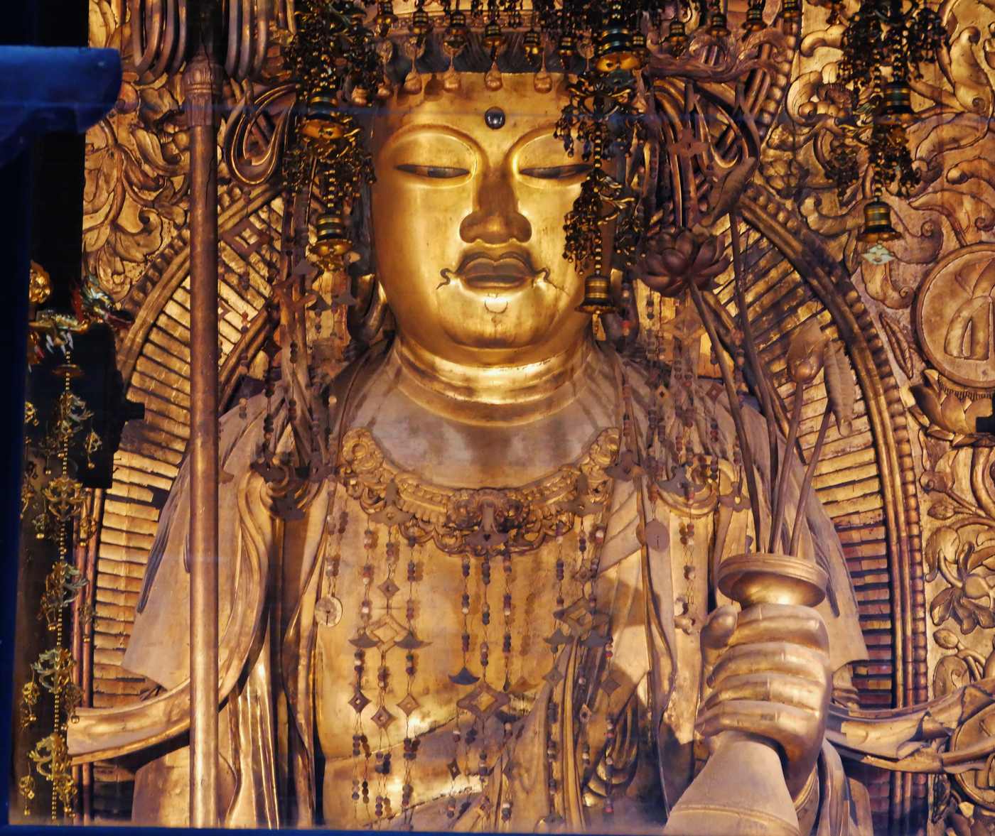 長谷寺本尊十一面觀音面容與寶冠瓔珞特寫,左手持華瓶、左緣可見錫杖