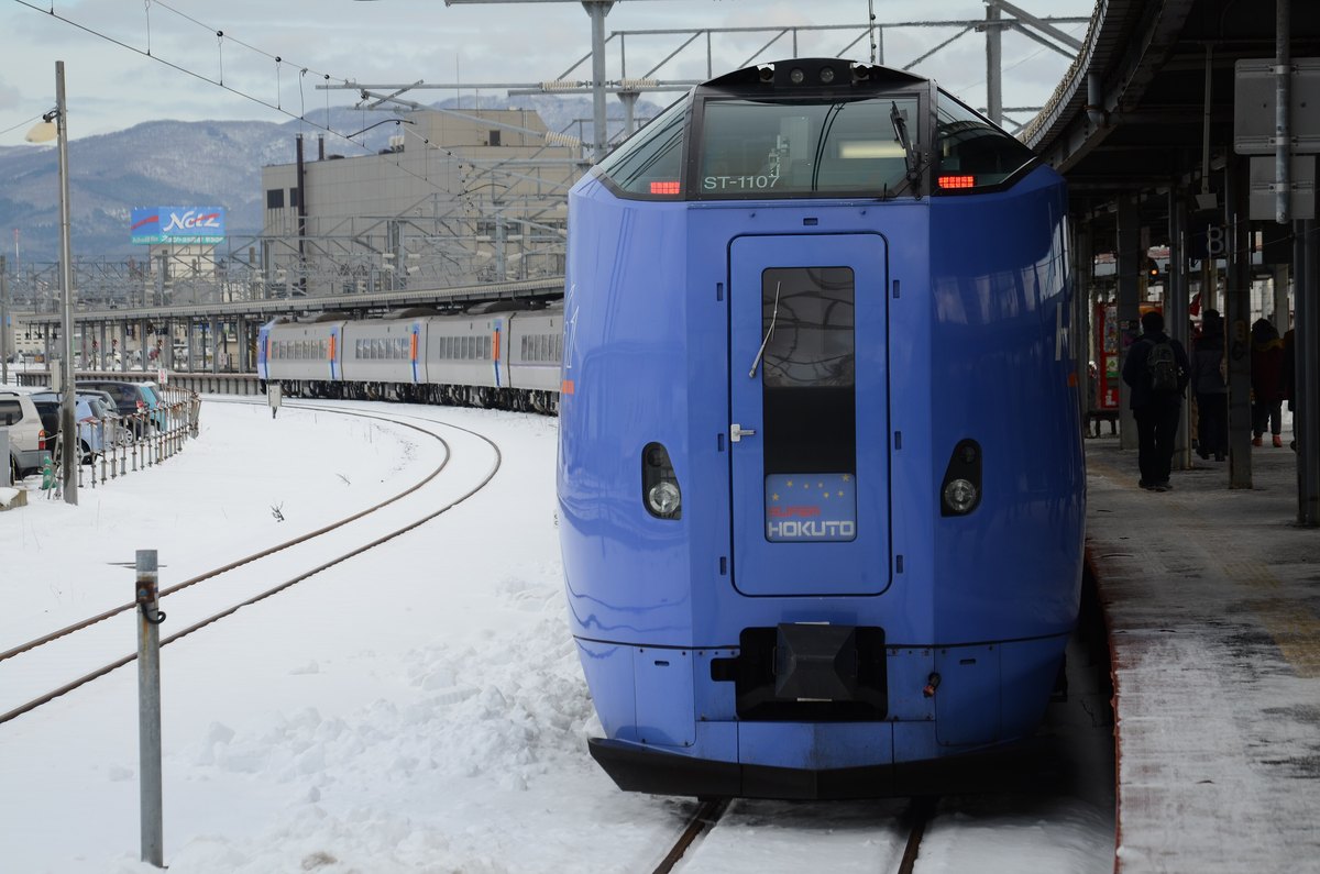 JR 北海道キハ261系「特急スーパー北斗」停靠積雪的函館車站月台,軌道與月台鋪滿殘雪