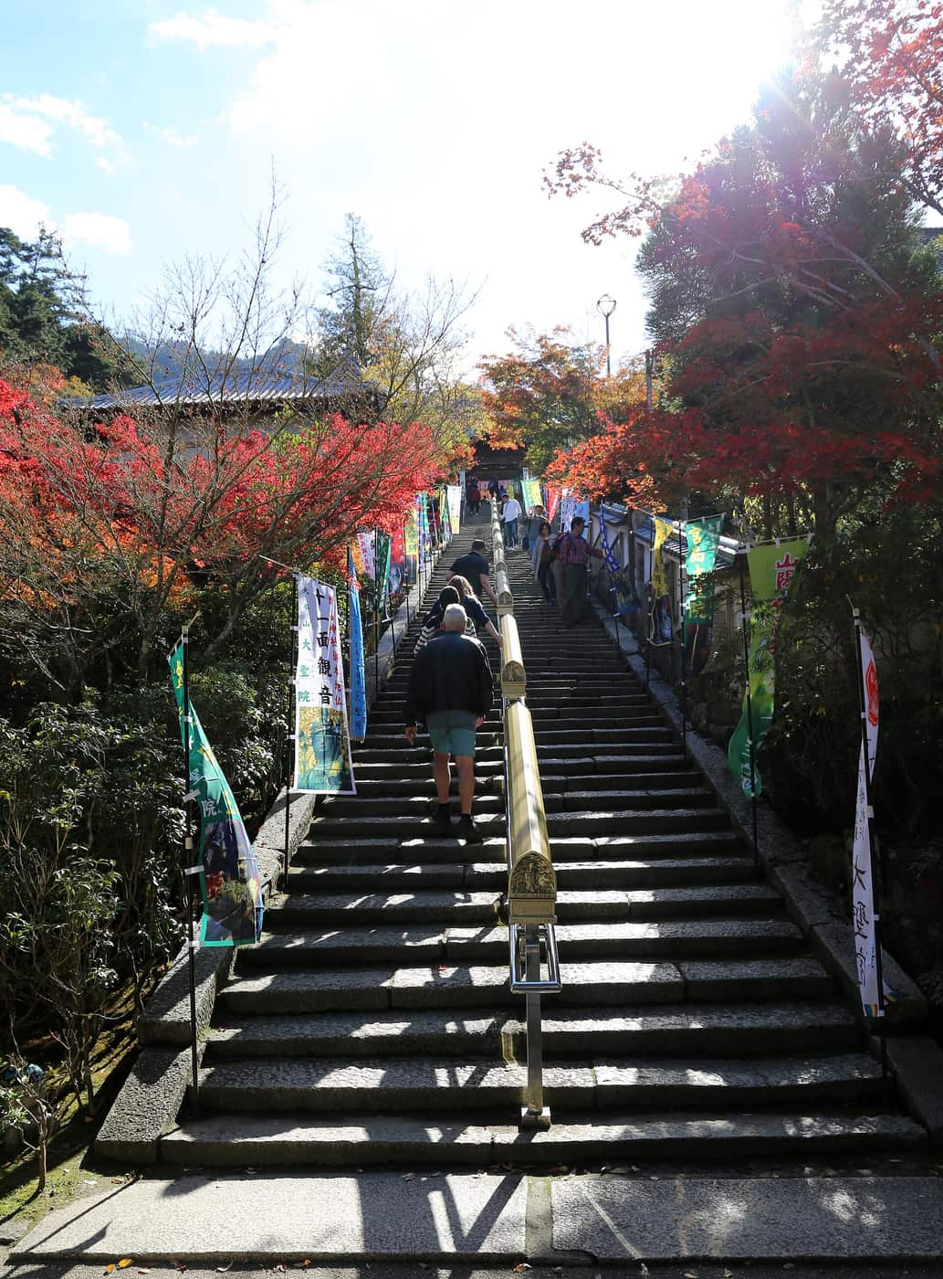 大聖院參道石階兩側掛著十一面觀音等幟旗,紅葉季遊客沿階而上