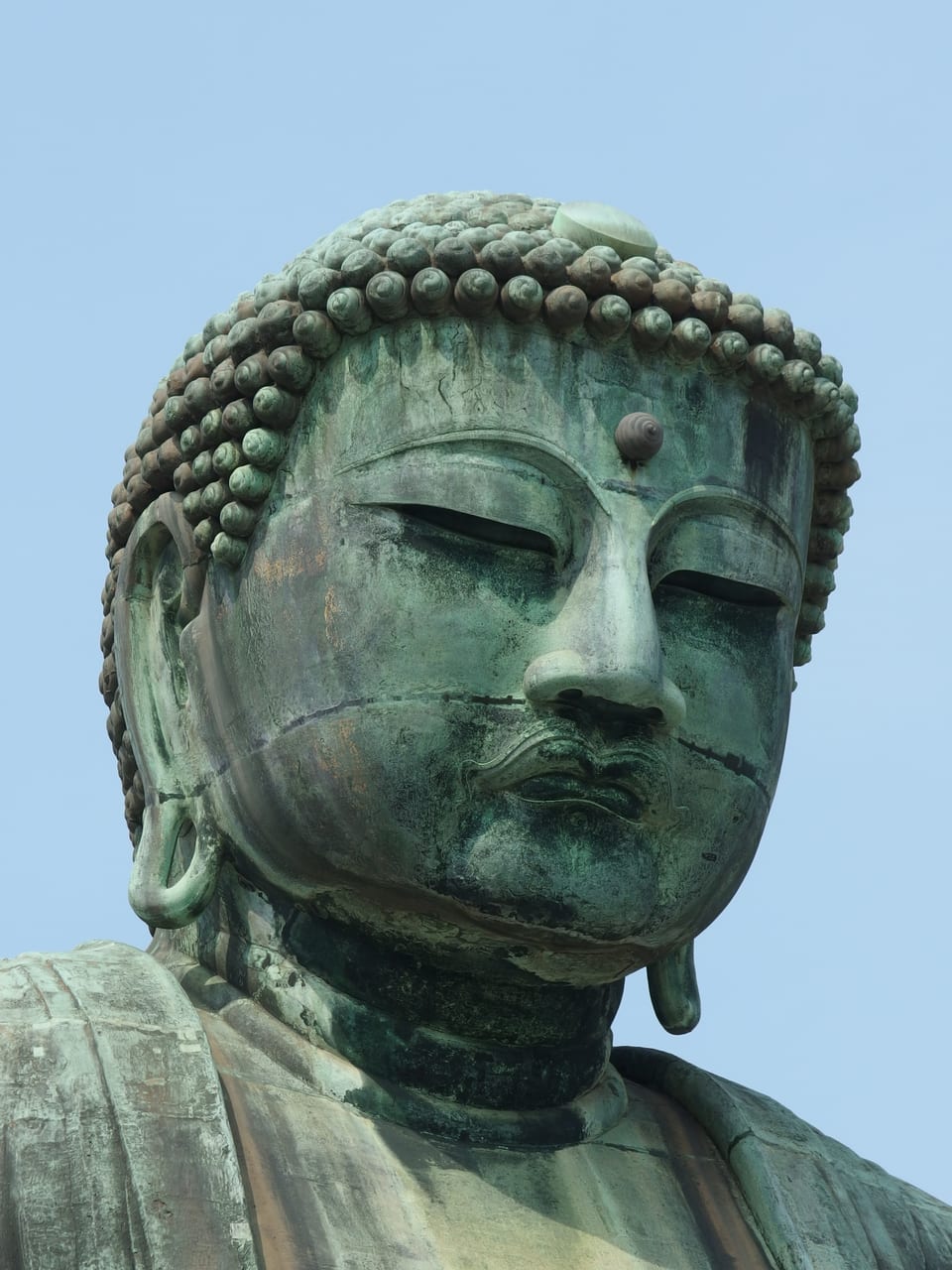 鎌倉高德院的青銅大佛坐像,露天矗立於藍天下