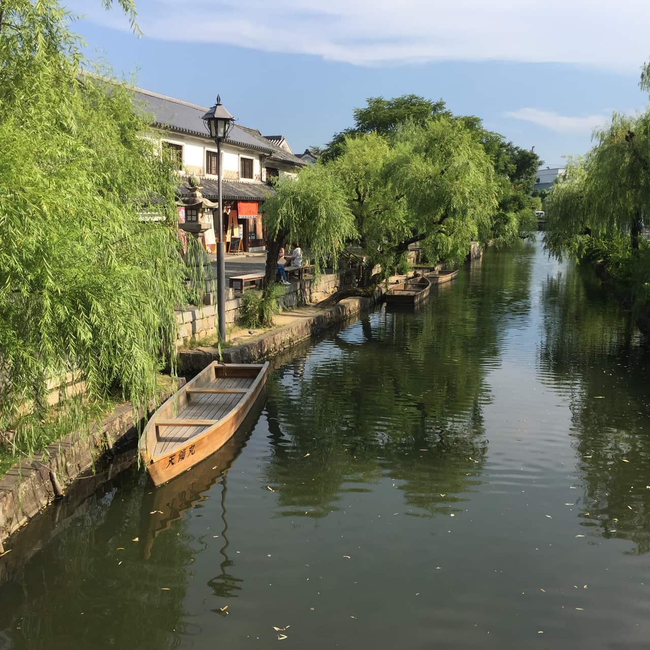 The Kurashiki River canal, willows, and white-walled storehouses of the Bikan quarter