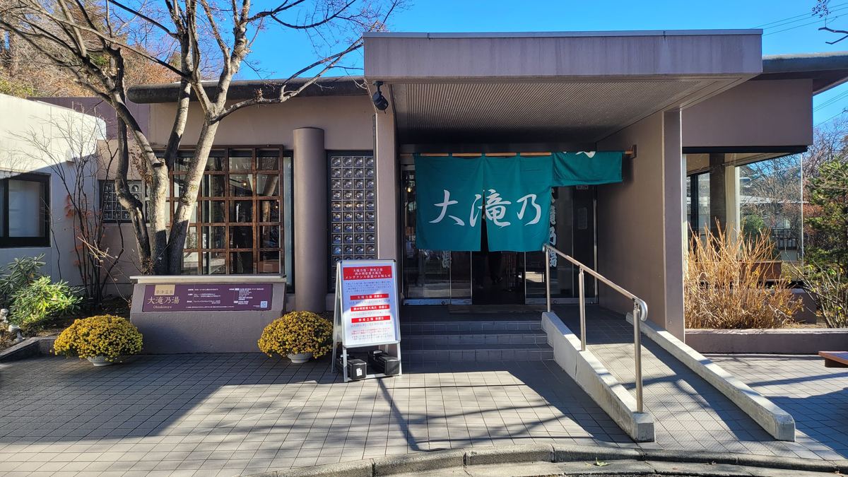大滝乃湯入口，綠色暖簾寫著「大滝乃」，門前立牌是三個町營浴場的維修休館通知