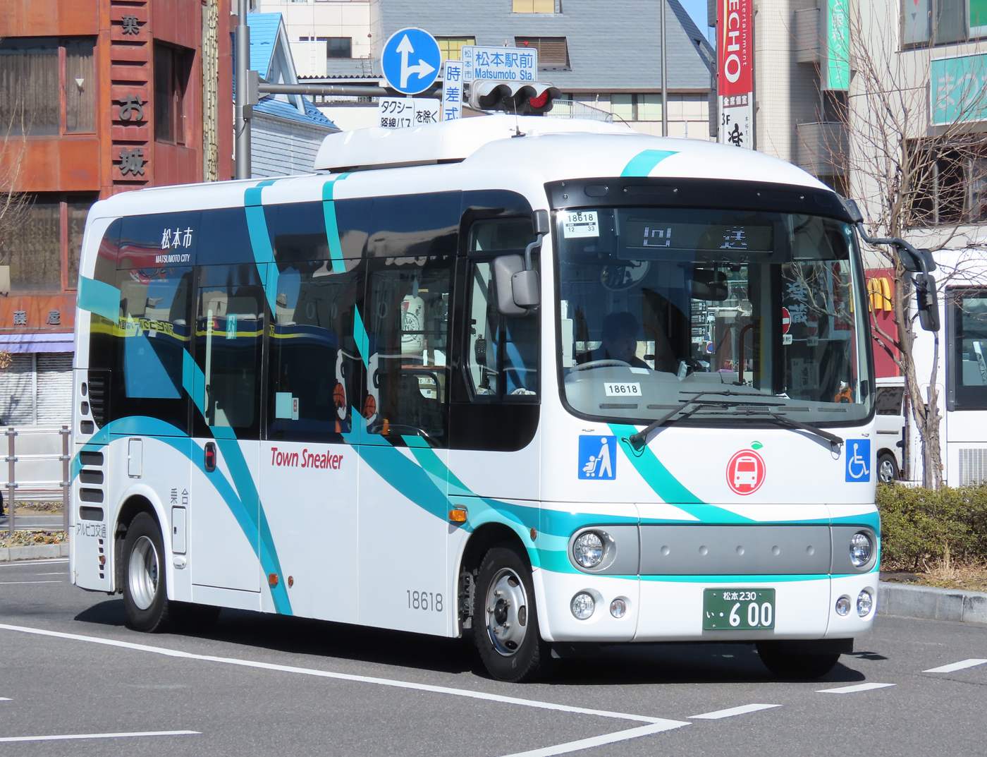 松本駅前路口的 Town Sneaker 周遊巴士，白底配水藍色線條的現行塗裝，車身寫著松本市與 Town Sneaker
