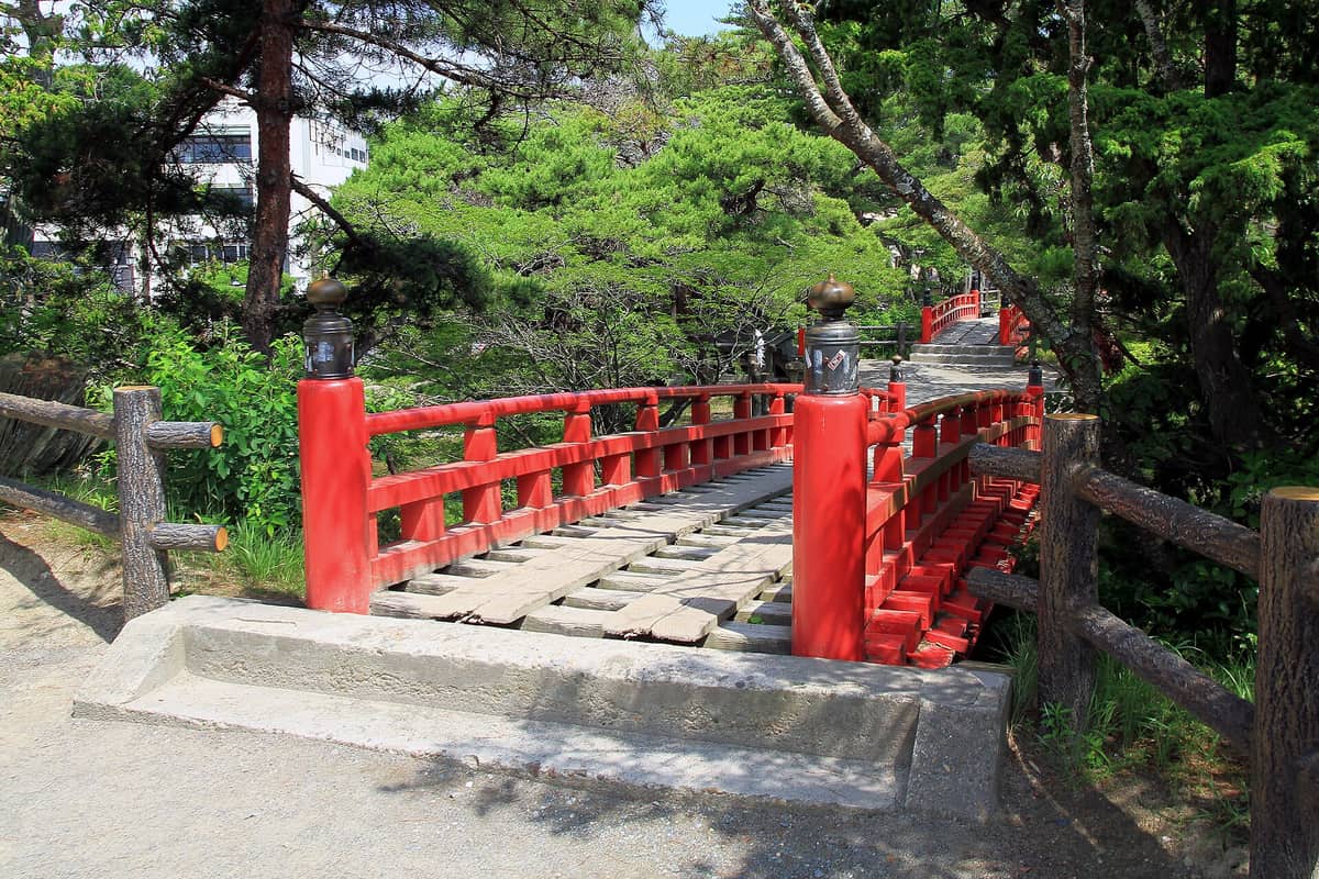 通往五大堂的朱紅色透かし橋，格狀橋面板條間可見下方海面
