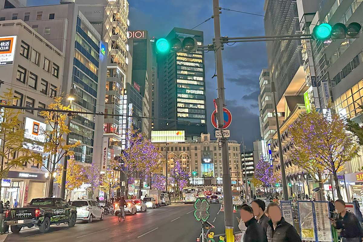 御堂筋南段難波一帶的傍晚街景，兩側行道樹點燈、金黃銀杏未落，正前方是南海難波站的南海大樓