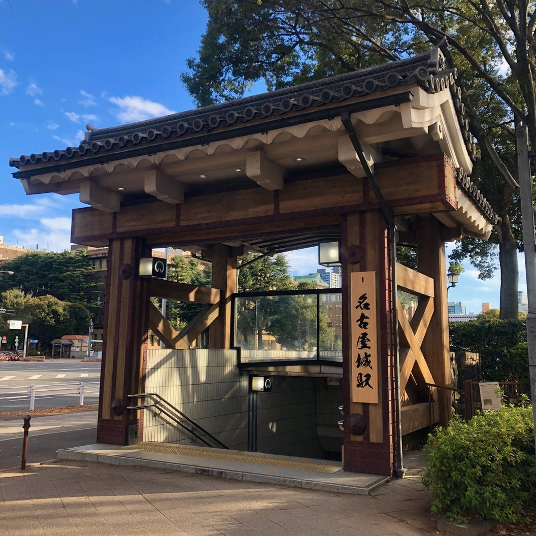 名古屋城站 7 號出入口:一座仿城郭木造屋頂的地下鐵出入口,右側立柱掛著寫有「名古屋城駅」的直式木牌,樓梯往地下延伸