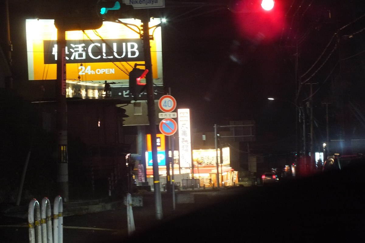 日本路邊網咖連鎖「快活CLUB」的夜間發光招牌,下方標著 24h OPEN