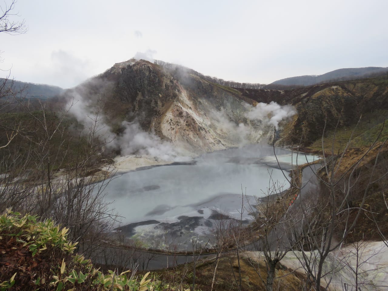登別大湯沼,火山噴發口積水形成的灰黑色硫磺熱水池冒著蒸氣