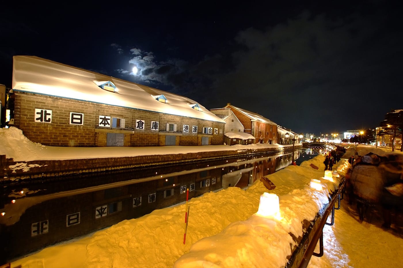 小樽雪あかりの路：運河沿岸積雪的石造倉庫群夜間點燈，步道上排列雪蠟燭