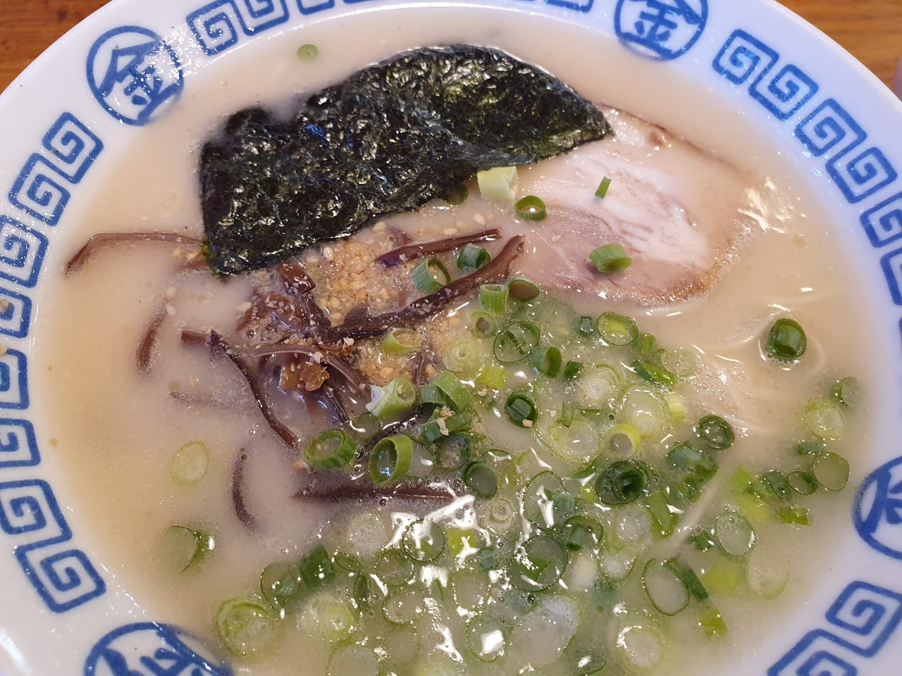 一碗豚骨拉麵,乳白濃稠湯底配細直麵、叉燒與蔥花