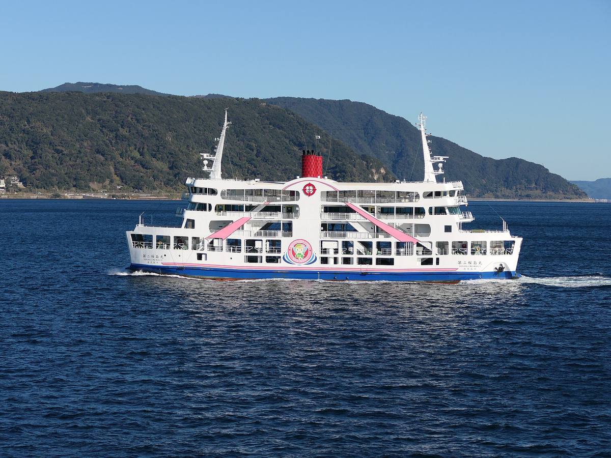 櫻島渡輪「第二櫻島丸」白底粉紅斜帶塗裝,行駛在錦江灣上