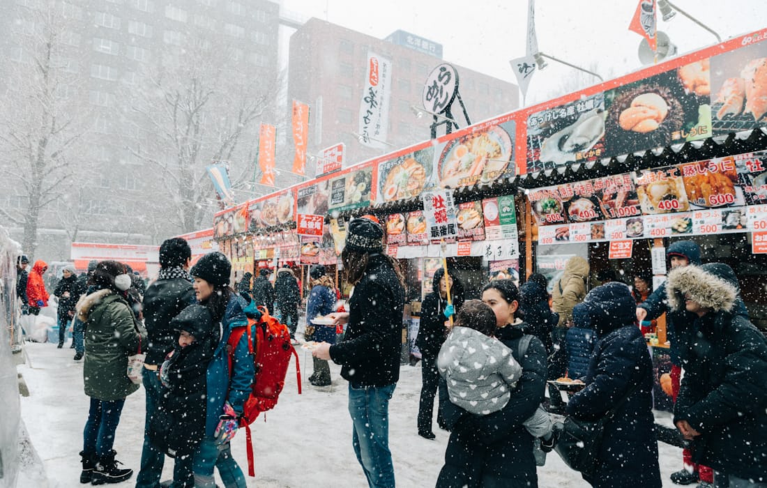 下雪中札幌市區攤位街與撐傘逛街的人潮