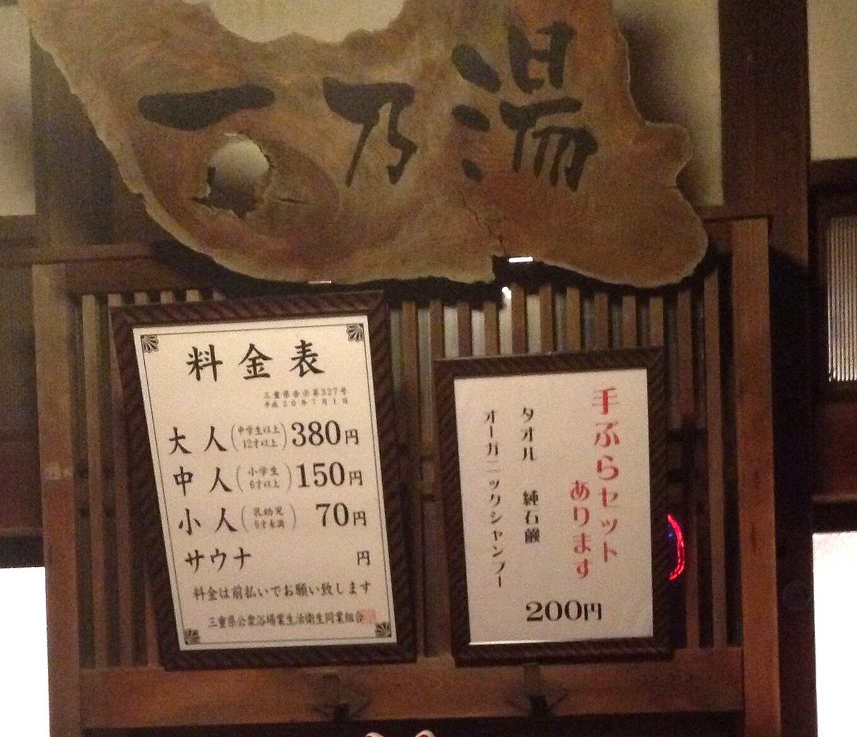 三重縣伊賀市錢湯「一乃湯」入口上方的木框料金表，分列大人、中人、小人三段金額，表頭標著縣告示號碼，右邊另一張是手ぶらセット 200 円的告示