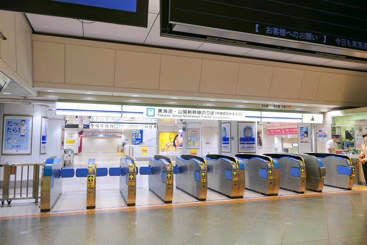 東京車站東海道・山陽新幹線的中央轉乘改札口，一整排藍銀色自動閘門全部亮著綠色通行箭頭，上方藍底指標寫著「東海道・山陽新幹線のりば（中央のりかえ入口）」，左側牆上貼著印有「だったら!」與スマートEX 標誌的海報，右側是有站員的窗口，地面空無一人