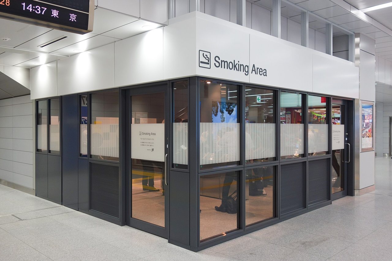 新大阪站新幹線改札內的玻璃隔間喫煙ルーム,招牌寫 Smoking Area,門上貼著僅限成年吸菸者的告示