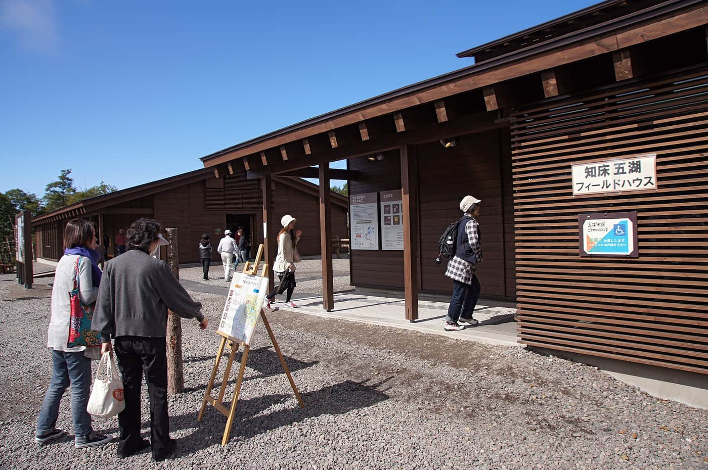 知床五湖フィールドハウス木造深色外觀,入口掛著知床五湖フィールドハウス看板