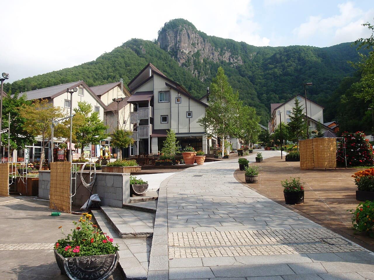 層雲峽溫泉街的石板步道與歐風建築,後方聳立著柱狀節理的岩峰