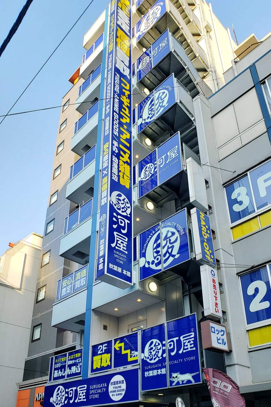 駿河屋秋葉原本館的大樓外觀,藍底白字的駿河屋招牌沿樓層垂直排列