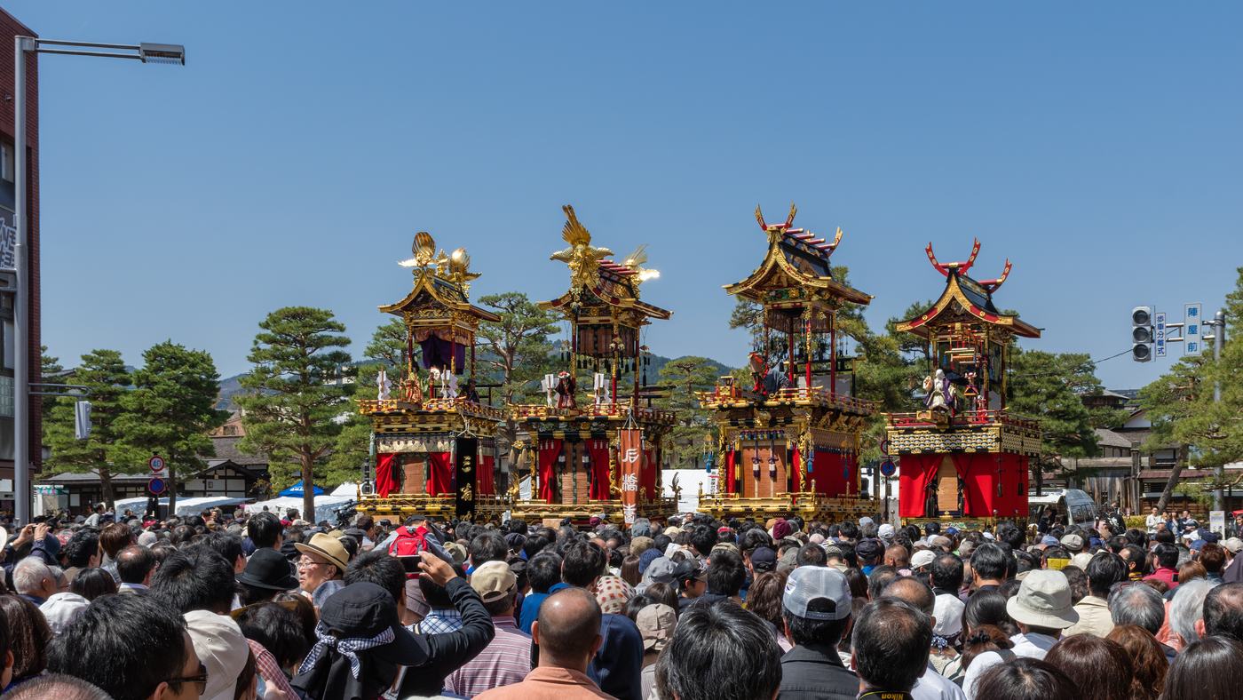 四台高山祭屋台並排展示,前方擠滿舉著手機拍照的立ち見人潮