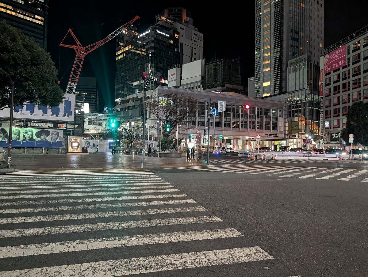 平日凌晨近 2 點的澀谷全向十字路口,斑馬線與車道幾乎空著,只有零星行人,車站那一側仍停著一排車