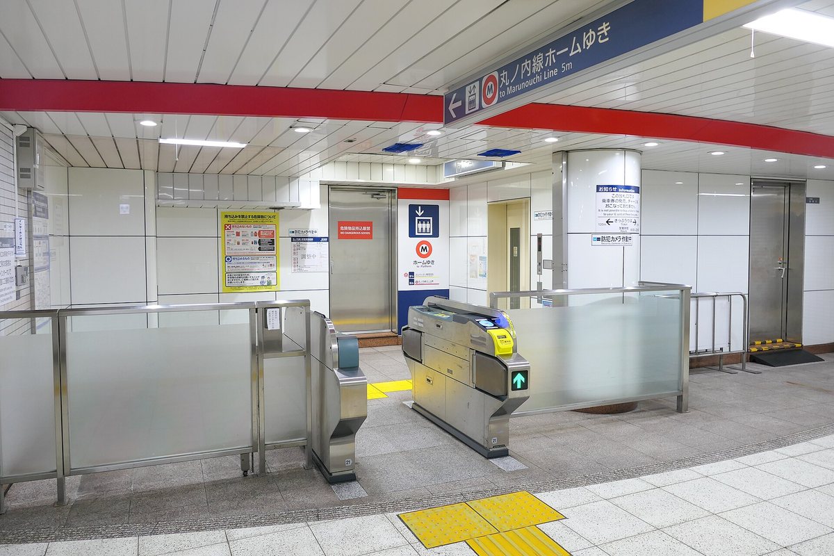 東京メトロ 荻窪站的電梯專用改札口,一台加寬式自動閘門亮著綠色箭頭,黃色導盲磚從閘門一路連到後方的不鏽鋼電梯門,電梯旁藍底立牌印著電梯圖示與「ホームゆき to Platform」,天花板懸吊指標寫「丸ノ内線ホームゆき to Marunouchi Line 5m」