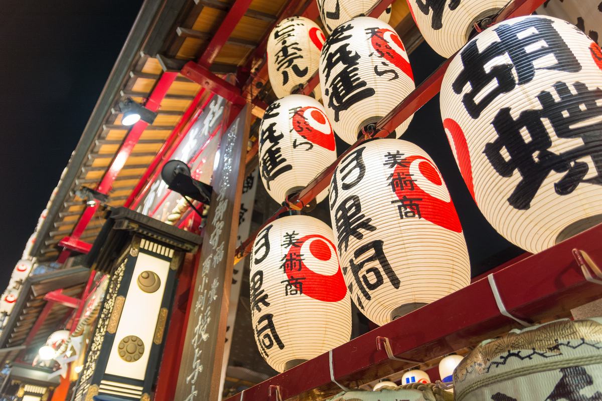 浅草鷲神社夜間的提燈架,成排白底紅巴紋提燈上寫著奉納商家的名號